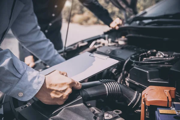 Otomobil tamircisi tamir edildikten sonra araç motoru sistemleri için kontrol listesi kullanıyor. Araba sigortası desteği ve hizmetleri kavramları.