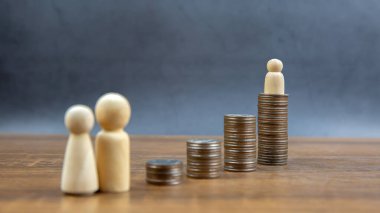 Birçok madeni para para biriktirmek ve finansal planlama sigortası için aile içi tahta bebeklerle bir grafik şeklinde istiflenir..