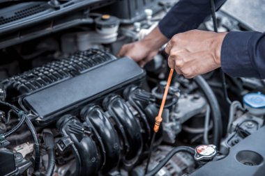Otomatik tamirci motor yağı seviyesini araba motor yağı değişimine kontrol ediyor 