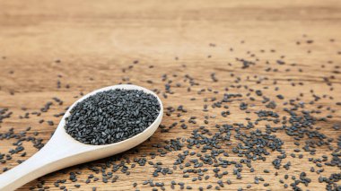 Sağlıklı yemek ve diyet kavramları için tahta kaşıkta siyah susam tohumları..
