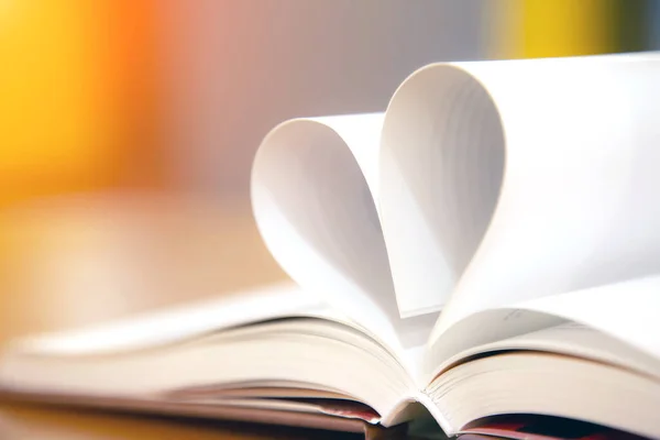 Close up image of a book  in heart shape on the table at library of lifestyle love to read and february valentine day concepts.