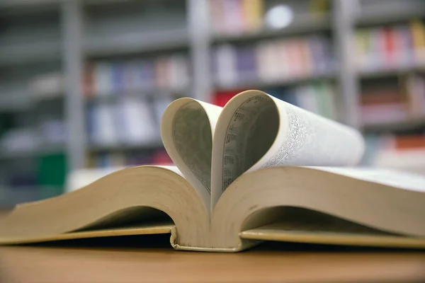 Close up image of a book  in heart shape on the table at library of lifestyle love to read and february valentine day concepts.