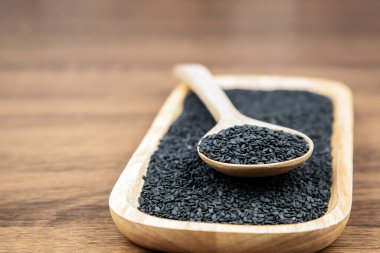 Sağlıklı yemek ve diyet kavramları için tahta kaşıkta siyah susam tohumları..