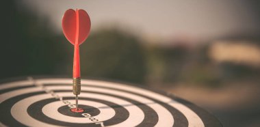 Hedef tahtası ya da dart tahtası ok atarak hedefin ortasına güneş ışığı ile vurur iş hedefleme ve kazanma hedefleri iş kavramları için..