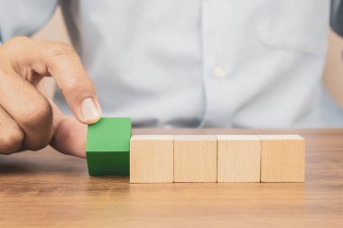 Yakın plan el, iş tasarımı konsepti için grafiksiz istiflenmiş bir küp tahta oyuncak bloğu ve çocuk vakfı uygulama becerileri için etkinlik seçin.