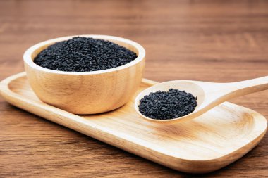 Sağlıklı yemek ve diyet kavramları için tahta kaşıkta siyah susam tohumları..