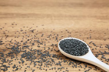 Sağlıklı yemek ve diyet kavramları için tahta kaşıkta siyah susam tohumları..