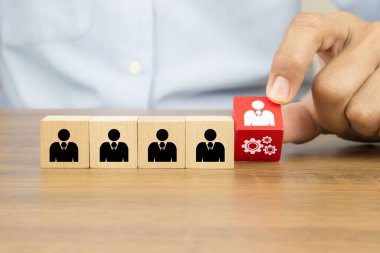 İş dünyası organizasyonları ve liderleri için insan kaynakları kavramlarının tahta oyuncak blokları üzerinde dişli simgesi olan insanları seçerken elinizi kaldırın..