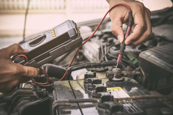 チェックカーバッテリーを修正するための測定機器ツールを使用して自動車整備士 旧車修理サービスと保険の概念 — ストック写真