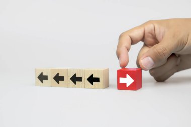 İş adamı eliyle, ok başı simgelerinin iş dünyasının büyüme ve başarı kavramlarının lideri için zıt yönleri gösterdiği tahta bloğu seçti.