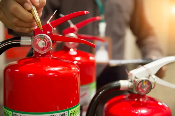 Tűzoltók Ellenőrzik Vörös Tűzoltó Tartályok Nyomásmérőjét Épületben — Stock Fotó