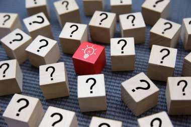 Küp tahta oyuncak blokları üzerinde soru işareti sembolünden gelen ampul simgesi. İş kuruluşları ve liderlik için insan kaynakları fikri kavramları..