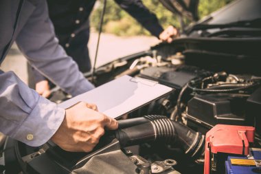 Otomobil tamircisi tamir edildikten sonra araç motoru sistemleri için kontrol listesi kullanıyor. Araba sigortası desteği ve hizmetleri kavramları.