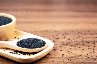 Sağlıklı yemek ve diyet kavramları için tahta kaşıkta siyah susam tohumları..