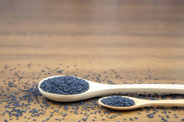 Sağlıklı yemek ve diyet kavramları için tahta kaşıkta siyah susam tohumları..