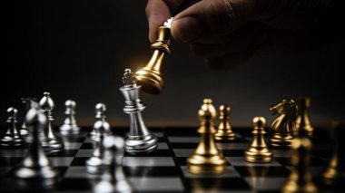 Yakın mesafeden satranç tahtasında gümüş satranç takımıyla dövüşmek için altın satrancı seçin iş stratejik planı ve profesyonel takım çalışması ve meydan okuma yönetimi kavramı.