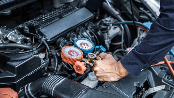 自動車整備士は カーエアコンの充填のための測定機器ツールを使用しています 車のケアの概念修理サービスと保険をチェック — ストック写真