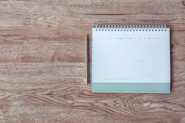 The top view blank calendar on desk office for copy space composition