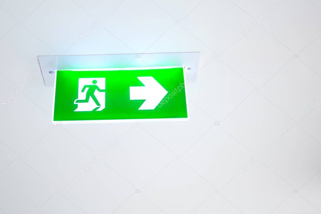 Green emergency fire exit sign or fire escape in the building ceiling emergency exit symbols in the event of a fire.
