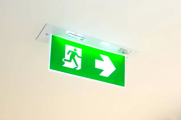 Green emergency fire exit sign or fire escape in the building ceiling emergency exit symbols in the event of a fire.