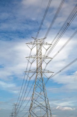 Yüksek voltaj iletim kulesi ve gökyüzü arka planına sahip kablolama.