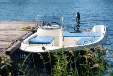 Slezska Harta marinasında elektrikli motoru olan küçük mavi bir tekne.