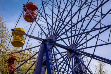 Eski mavi dönme dolabın altında. Sarı ve kırmızı kabinler açıldı. Çekim.