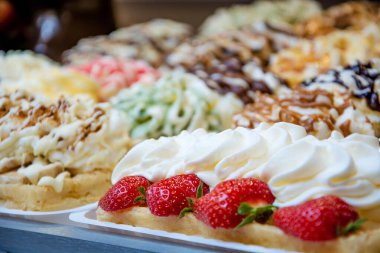 Farklı malzemelerle lezzetli Belçika wafflelarının yakın çekimi. Krem şanti ve çilek. Tatlı nefis..