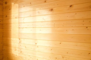 Duvar kaplaması için tahtalar. Ahşap duvarda ışık var. Arkaplan.