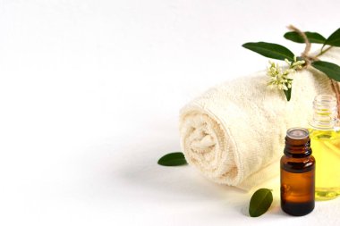 Havlu, çiçek, aromatik yağ, banyo yağı ve vücut jeli ile beyaz arka planda fotokopi alanı ile kaplıca hayatı