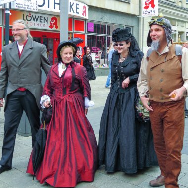  Wave Gothic Meeting, Mayıs 2015, Leipzig, Almanya: Geleneksel gotik giysili iki yetişkin şehir merkezinde cadde boyunca yürüyor