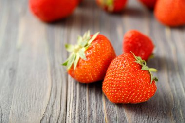 Fotokopi alanı olan eski ahşap bir arka planda taze tatlı çilek yakın plan