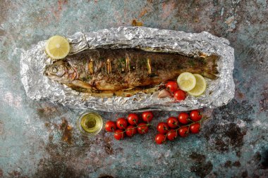 Folyo fırınlanmış alabalık, limonlu, domatesli ve yağlı.