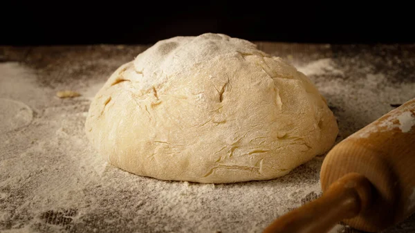 Bir somun ekmek için maya hamuru ya da un ile ahşap masada pişirilen diğer şeyler..