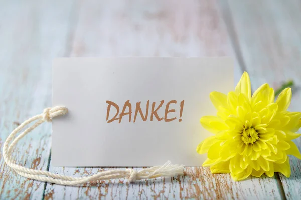Alman metniyle kasımpatı çiçeği Danke (İngilizce teşekkürler) kartı ahşap arka planda