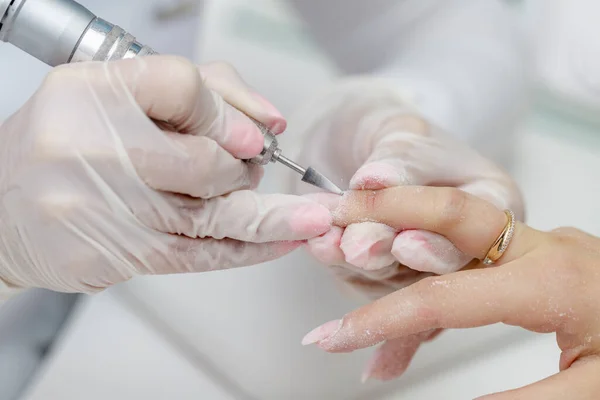 Manicure procedure with device in beauty salon. Process closeup
