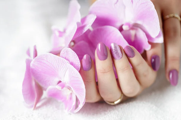 Eleganckie Kobiece Dłonie Świeżym Różowym Manicure Liliowym Kwiatem Storczyka Leżącego — Zdjęcie stockowe