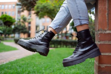 Mavi kotlu deri botlar, sokak arka planı, oturma, açık hava, yaşam tarzı.