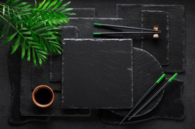 Siyah kaya kayrak plaka üzerinde chopsticks ve bambu kase