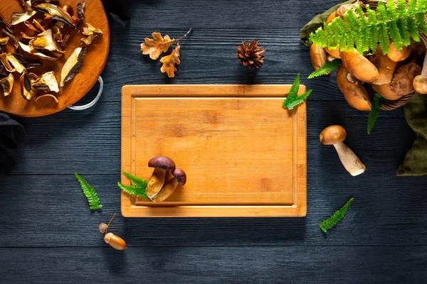 Champignon forestier et planche à découper sur table noire. Espace de copie — Photo