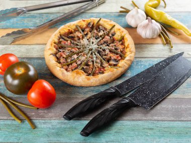 Tahtada pizza, sebze ve sarımsaklı renkli arka plan.