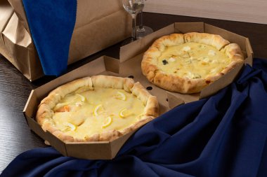 Mavi arka planda somonlu peynirli pizza ve gözlük.