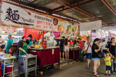 Dokuz İmparator Tanrıları Festivali sırasında, bazı tezgahlarda vejetaryen yiyecekler satılıyor. İnsanlar tezgahtan yiyecek alırken görülebiliyor.