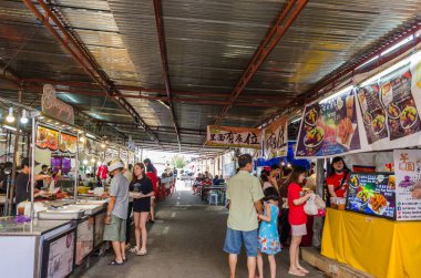 Dokuz İmparator Tanrıları Festivali sırasında, bazı tezgahlarda vejetaryen yiyecekler satılıyor. İnsanlar tezgahtan yiyecek alırken görülebiliyor.