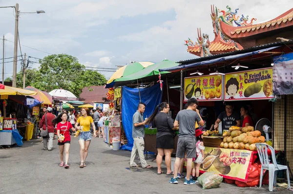 During the Nine Emperor Gods Festival,there are some stalls selling religious prayer ornaments and vegetarian foods, people can seen exploring around it. — Stock Photo, Image