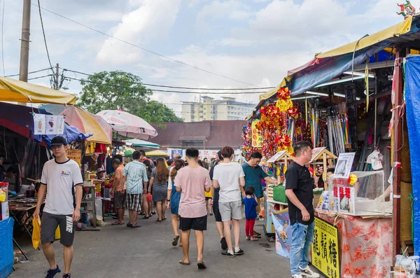 During the Nine Emperor Gods Festival,there are some stalls selling religious prayer ornaments and vegetarian foods, people can seen exploring around it. — Stock Photo, Image