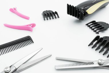 Saç makasları kablosuz elektrikli saç makasıyla kuaförlük araçları beyaz arka planda izole edilir.