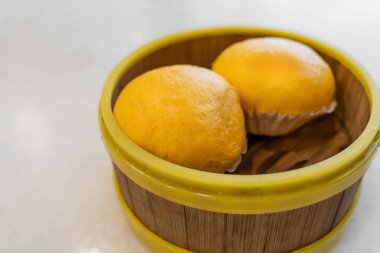 İki lezzetli altın lav buğulamalı çöreğin olduğu ahşap sepet.