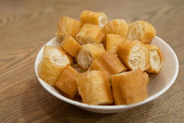 Lezzetli geleneksel Çin hamur çubukları bir kasede servis edilir. Çıtır çıtır ve altın sarısı, bu abur cuburlar ya kahvaltılarda ya da sokak yemekleri olarak popülerdir. Soya sütü ve diğer içeceklerle mükemmel..