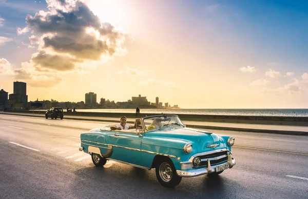 Havana, Küba - Ekim 04, 2018: Amerikan kırmızısı 1956 Chevrolet mavi naneli Bel Air üstü açık klasik araba ve turistler Havana City Küba 'da akşam güneşinde Malecon gezinti alanında — Stok fotoğraf